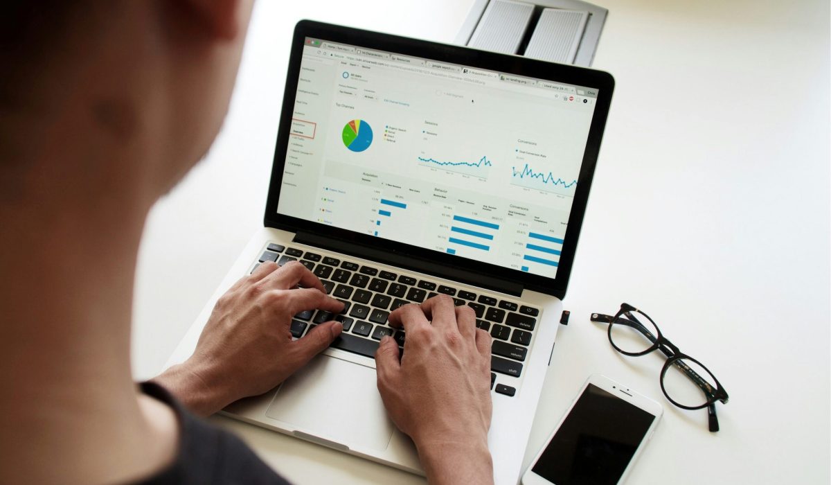 Pessoa digitando no notebook dados para elaboração de gráficos.